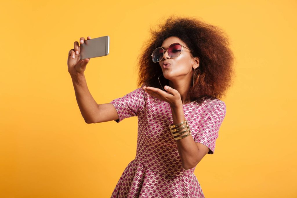 Young woman taking a picture of herself for a royalty-free image website